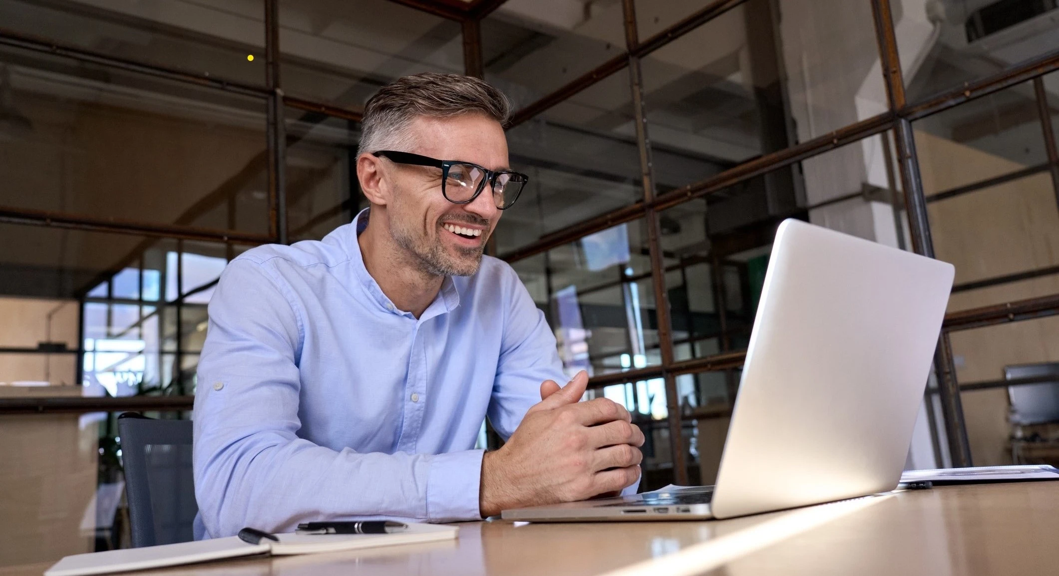 Meneer zit achter laptop te beeldbellen met WeSeeDo in de financiele sector